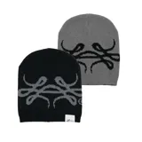 Beanie reversible tejido en algodón, con diseño gráfico abstracto. Presenta un lado en color negro con estampa gris y el otro lado en color gris con estampa negra. Incluye etiqueta de marca en el borde inferior.
