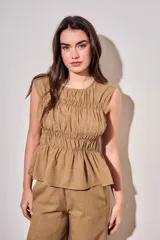 Blusa sin mangas de viscosa con estampado a cuadros vichy en tonos marrones y tostados, con doble fruncido elástico en el pecho y la cintura que genera un sutil vuelo inferior.