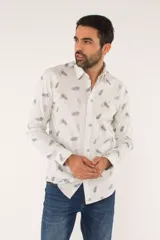 Camisa de manga larga con corte slim fit, color blanco con estampado de hojas pequeñas en tonos grises y azules. Presenta cuello clásico, cierre frontal con botones y logo bordado en el pecho.