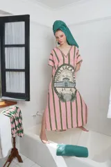 Túnica larga de corte holgado con estampado de rayas verticales rosas y verdes. Presenta un estampado circular con la leyenda "Hotel Vacances The Farra" y un dibujo de un edificio y una concha. Tiene escote en V con ribete bordado y tajos laterales.