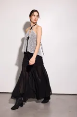 Falda larga de gasa negra con forrería en la parte de las caderas, con frunces y largo godet.