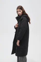 Campera larga tipo parka acolchada color negro, con capucha desmontable, cierre frontal con botones a presión, bolsillos laterales y cordón ajustable en la cintura.