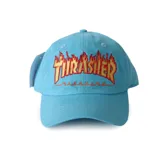Gorra de visera curva color celeste, con el logo clásico de Thrasher bordado en el frente con diseño de llamas en tonos naranja y amarillo.