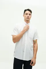 Camisa de manga corta confeccionada en una mezcla de lino y algodón, con cuello clásico, cierre frontal de botones y bolsillo en el pecho con logo bordado.