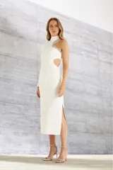 Vestido midi blanco con cuello alto, manga larga y abertura lateral. Presenta un corte en la cintura y un recorte en la espalda con detalle de cristales.