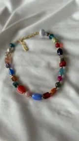 Collar corto con cuentas de colores y cadena de ajuste.