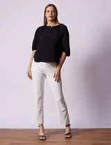 Blusa de gasa blanca con estampado de hojas en azul marino, cuello a la base con escote en V y botones, y mangas cortas abullonadas.