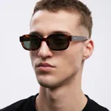 Lentes de sol ovalados con montura de carey marrón y lentes verdes polarizadas.