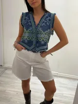 Bermuda color borgoña de gabardina elastizada, corte a la rodilla, con cinto fino con tachas y detalles de flecos en el ruedo.