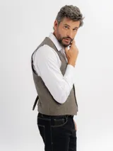 Chaleco de paño con escote en V, cierre frontal con botones y bolsillos tipo ojal. Presenta un diseño clásico de corte regular.