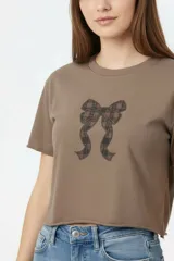 Remera cropped de algodón negra con cuello a la base, mangas cortas y estampado frontal de cerezas con la palabra "HELLO".