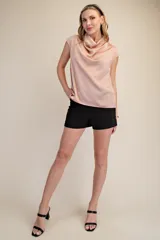 Top sin mangas de satén color rosa pálido, con cuello tipo cowl drapeado y corte recto.