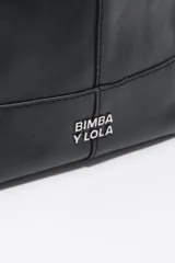 Bolso de mano Bimba y Lola modelo Paper mediano, confeccionado en cuero color tostado con estructura blanda, asas superiores y correa de hombro ajustable en color beige. Presenta costuras visibles, logo metálico de la marca en la parte inferior y cierre principal.