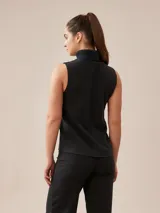 Polera sin mangas de tejido de punto color gris, con cuello alto vuelto y costuras decorativas frontales.