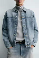 Cazadora de denim de algodón con efecto lavado, corte regular fit, cuello solapa, cierre frontal con botones, mangas largas con puños abotonados y bolsillos laterales de vivo.