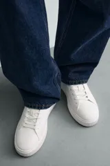 Zapatillas deportivas de cordones, color blanco, con suela gruesa.