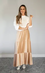 Pollera larga de satén color beige, con diseño holgado y ruedo con volado.