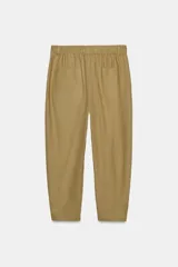 Pantalón capri color verde oliva, de tiro medio, confeccionado en mezcla de lino. Presenta bolsillos laterales y traseros, y cierre frontal con cremallera y botón.