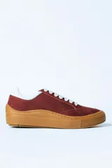 Championes urbanos de gamuza color bordó con suela de goma color caramelo y cordones blancos.