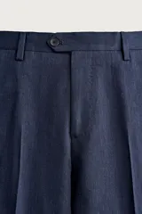Pantalón de traje de corte regular fit en color azul marino, confeccionado en una mezcla de lino y lana. Cuenta con bolsillos delanteros, bolsillos traseros de doble vivo con botón y raya marcada en el centro de las piernas.