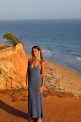 Vestido largo de punto color azul con sutiles motas beige, de corte recto, con tirantes finos regulables, escote redondo y pequeño tajo lateral en el bajo.