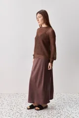 Sweater calado de punto negro, con cuello redondo y mangas largas, de diseño liviano ideal para superposiciones.