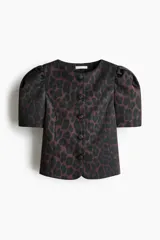 Blusa de sarga con estampado de leopardo, ajuste entallado, escote redondo, botones forrados frontales y mangas cortas abullonadas con pliegues en los hombros.