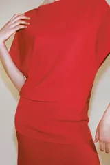 Top de punto liso color rojo, con cuello barco y mangas cortas de diseño amplio.