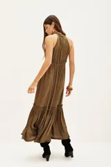 Vestido largo color verde oliva, con cuello halter fruncido, talle ajustado con elástico y falda con volados en capas.