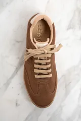 Zapatillas bajas de gamuza color marrón con cordones y suela de goma color caramelo.
