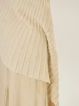 Chal de punto color beige con textura acanalada y sutil brillo metalizado.