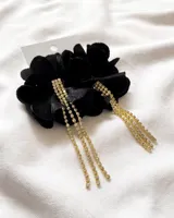Aros colgantes con forma de flor negra de tela y tres tiras de strass dorados.