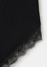 Vestido midi negro confeccionado en tejido de punto acanalado, con tirantes finos, escote en V y detalles de encaje en el escote y en el bajo asimétrico.