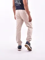Pantalón tipo jogger de gabardina, con cintura elástica ajustable mediante cordón y puños elásticos en los tobillos.