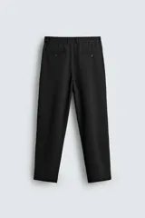 Pantalón de corte recto confeccionado en tejido elástico, con cintura elástica, pliegues frontales, bolsillos laterales y bolsillos traseros de vivo con botón.