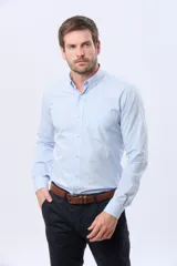 Camisa de manga larga con diseño a cuadros vichy en tonos celeste y blanco, cuello abotonado y cierre frontal de botones.
