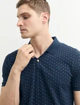 Remera polo azul marino con estampado de pequeños puntos blancos, cuello clásico con tres botones y mangas cortas.