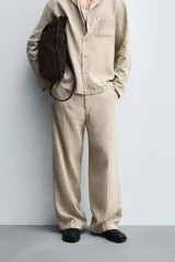 Pantalón de corte relaxed fit confeccionado en una mezcla de lyocell y lino. Presenta bolsillos frontales, bolsillos traseros de vivo y cierre frontal con cremallera y botón.