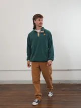 Buzo de pana color beige con cuello polo abotonado y bolsillo en el pecho.