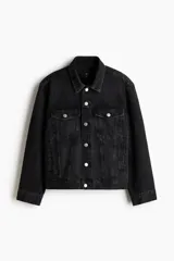 Campera trucker de denim rígido en color negro, con cuello camisero, cierre frontal de botones metálicos, bolsillos con solapa en el pecho y bolsillos laterales.