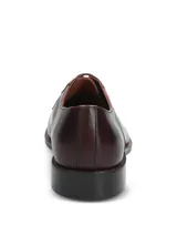 Zapato de vestir formal tipo derby, confeccionado en cuero vacuno color vino con acabado brillante. Presenta cierre mediante cordones al tono, costuras reforzadas y suela de goma resistente.