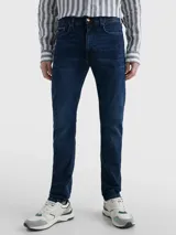 Pantalón de jean Tommy Hilfiger modelo Bleecker, corte slim, color azul oscuro. Confeccionado en tejido denim Power Stretch de mezcla de algodón, con efecto desteñido en las rodillas, estilo de cinco bolsillos y logo bordado en el bolsillo trasero.
