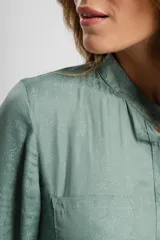 Camisa verde con cuello mao, de manga larga con puños abotonados y cierre frontal con botones.