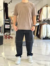 Remera oversize gris con efecto acid wash, de mangas cortas y cuello redondo, con estampado tipográfico blanco en la espalda.