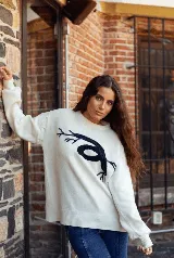 Sweater de punto color blanco con diseño de raíces en color azul marino en el frente, de corte holgado, cuello redondo y mangas largas con puños ajustados.