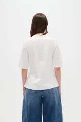 Remera negra de manga corta, con cuello redondo y diseño holgado con detalle de lazo para anudar en la cintura.