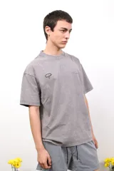 Remera gris de algodón con efecto acid wash, cuello redondo, manga corta y estampado en el frente y la espalda.