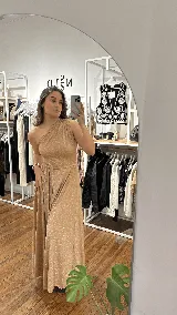Vestido largo de fiesta color azul oscuro con acabado brillante, diseño de un solo hombro con detalle de cuello tipo choker y falda amplia con caída fluida.