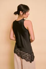 Blusa sin mangas de satén color tostado, con cuello redondo drapeado y detalle asimétrico de encaje en el ruedo.