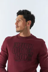Buzo de felpa color bordó con cuello redondo, mangas largas y corte regular. Presenta un estampado con la frase "Think out of the box" en el frente y logo de la marca bordado.